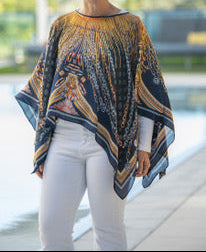 Woman wearing a patterned poncho with a blurred outdoor background